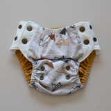Kekoa flexible stretch wing swim nappy in Paper Planes print. From 4-19kg (9lbs - 42lbs) in a one size OSFM design. Mustard yellow coloured AWJ lining.